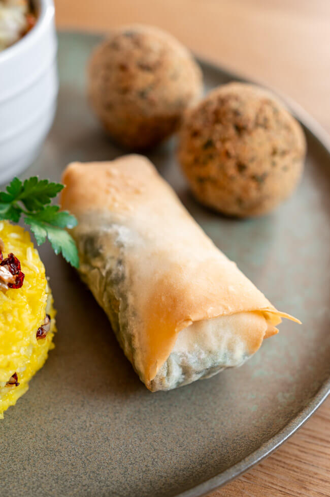 Börek auf grünem Teller zusammen mit Falafel Bällchen