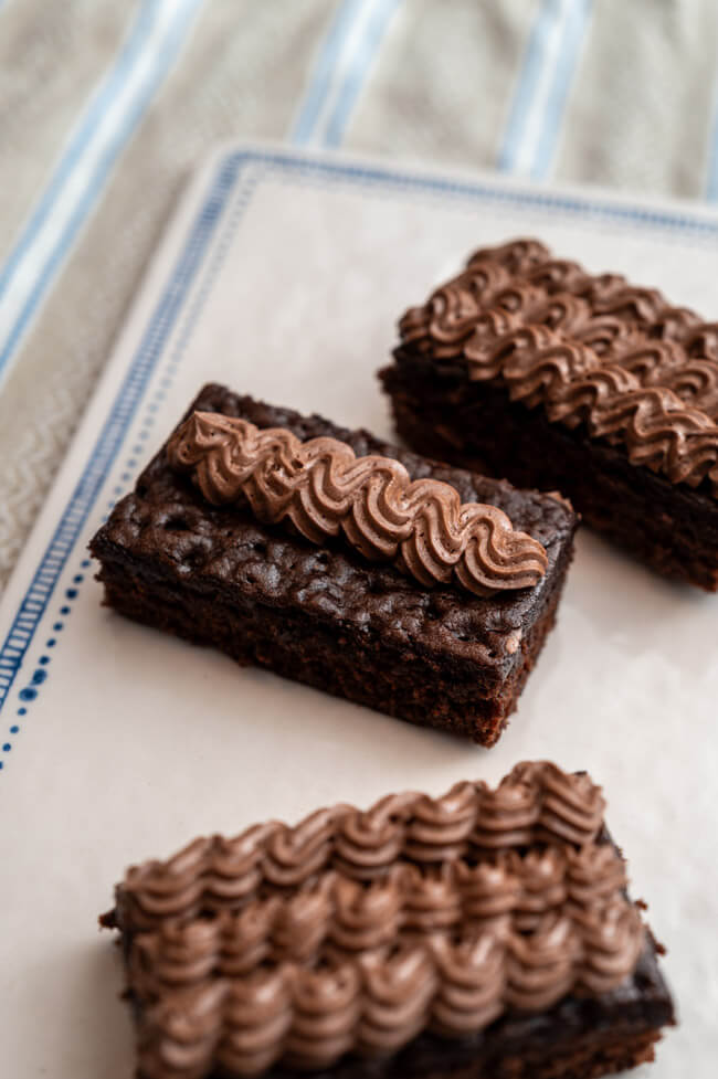 Gewürzkuchen mit Schokoladenbuttercreme auf weißem Keramiktablett