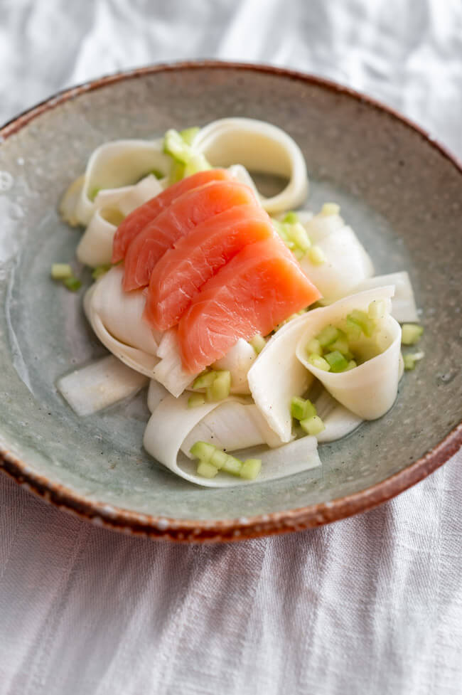 Balik Lachs aufgeschnitten auf rohem Spargelsalat mit Gurken Brunoises