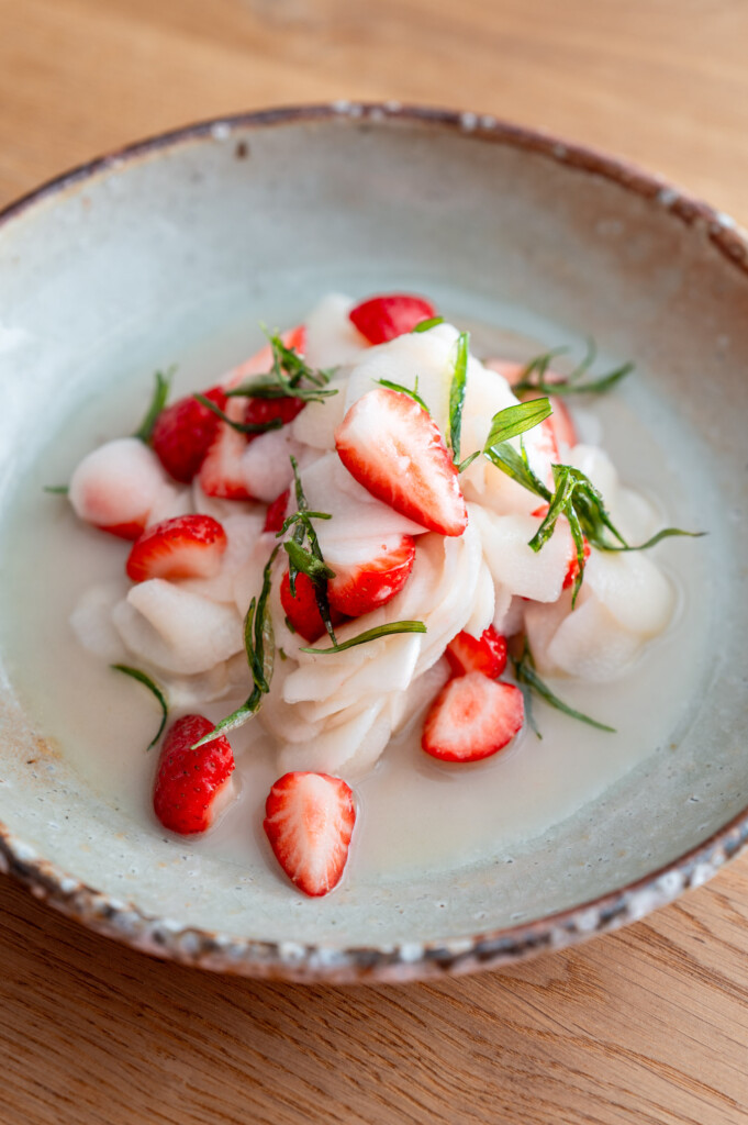 Roher Spargelsalat mit Erdbeeren und frittiertem Estragon, angerichtet auf handgetöpfertem Keramikteller von Markus Böhm.