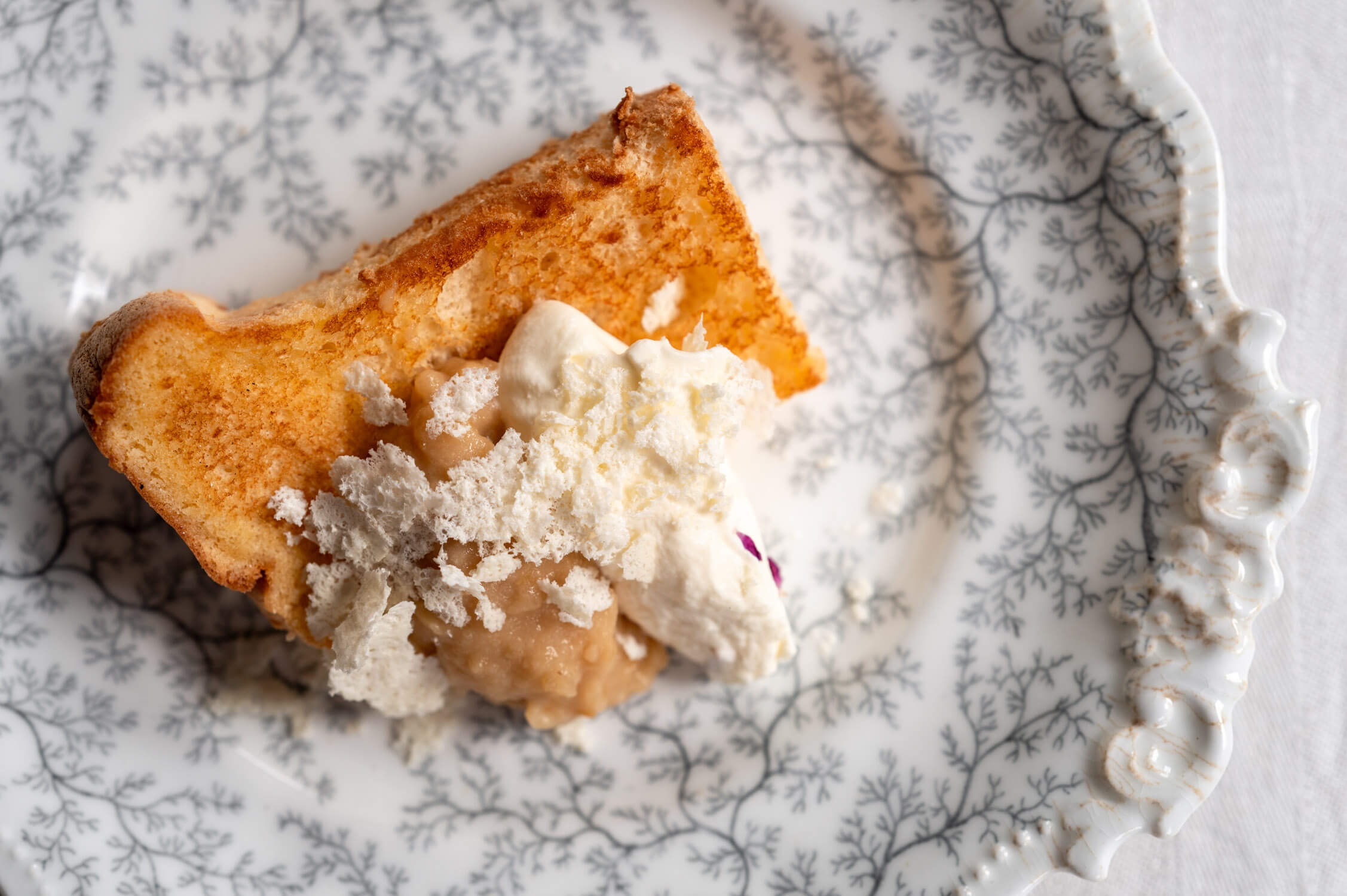 Ein Stück Chiffon Cake mit Apfelmus, Rosencreme und Feigenblattschnee auf antikem, schottischen Porzellanteller