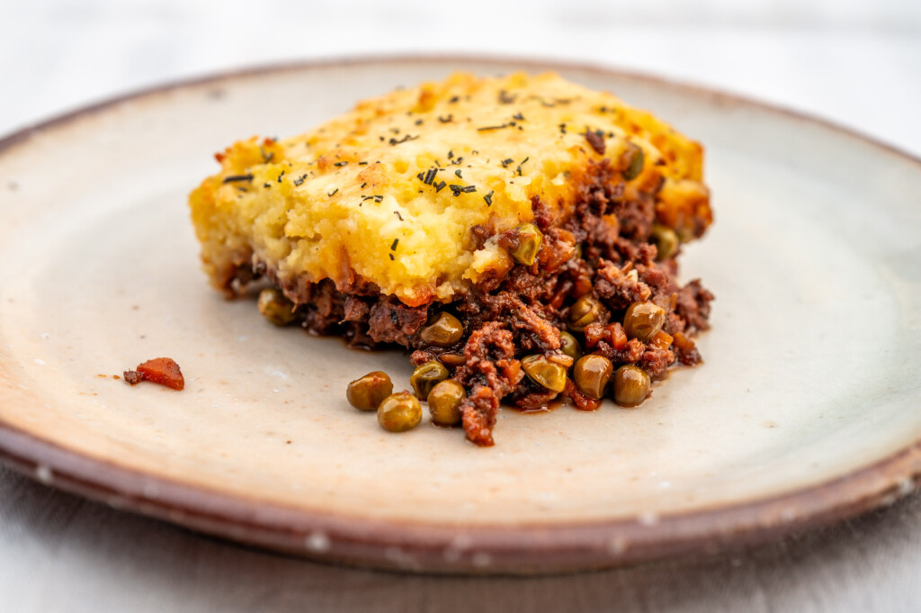 Ein Stück Sheperd's Pie auf hellem Keramikteller