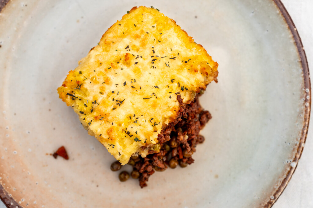 Ein Stück Sheperd's Pie auf hellem Keramikteller