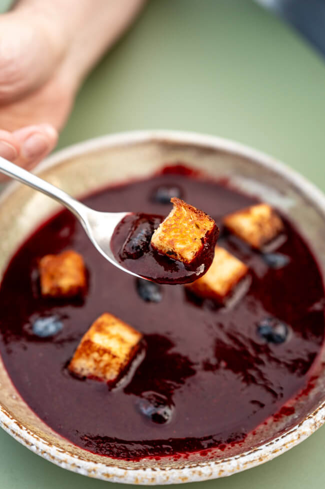Haskap-Beeren Gazpacho mit Brioche auf grünem Untergrund